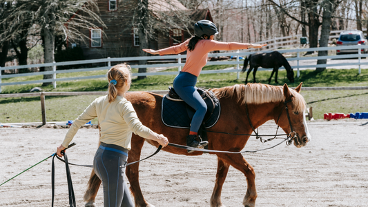 Girl on horseback with trainer