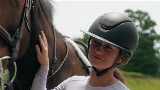 equestrian wearing LeMieux Verv helmet next horse